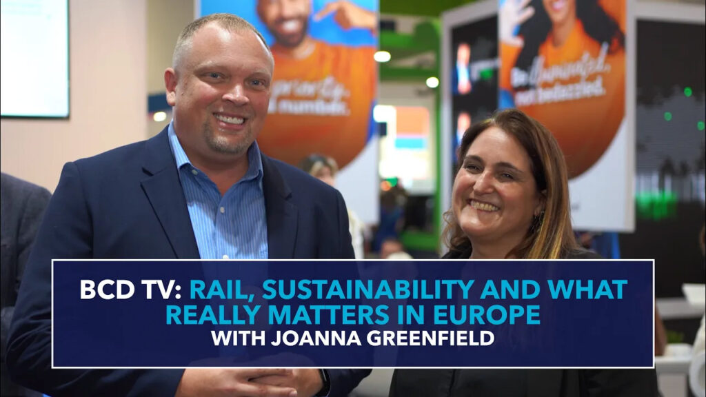 Two people smiling, BCD TV interview backdrop