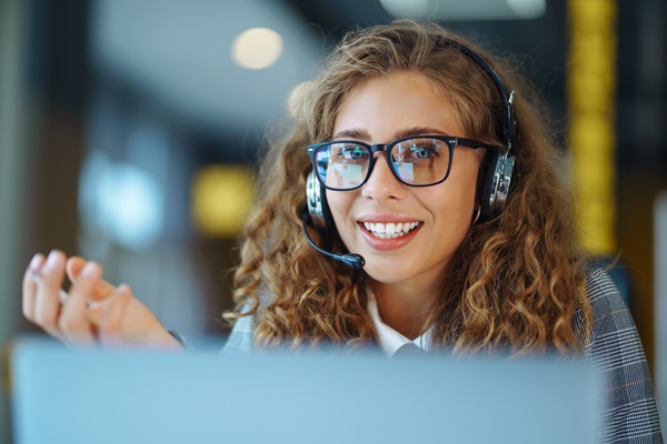 Smiling woman with headset ready to assist