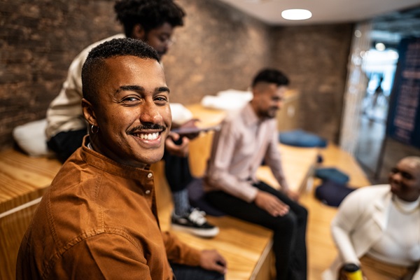 Personas sonrientes sentadas en escalones interiores.