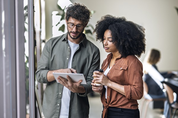 Two people discussing work on a tablet.