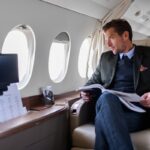 Man reading magazine on luxury private jet