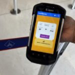 Hand hält ein mobiles Check-in-Gerät am Flughafen.