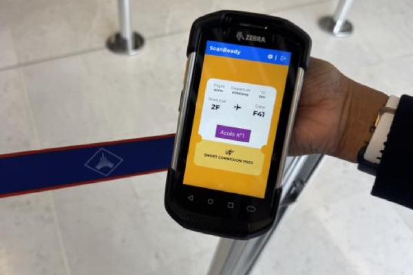 Hand hält ein mobiles Check-in-Gerät am Flughafen.