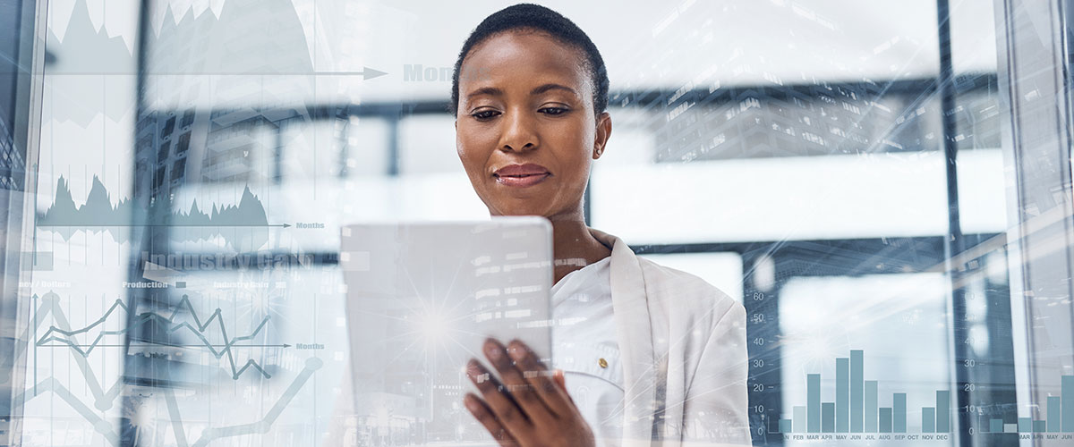 Businesswoman analyzing data on tablet with graphs overlay.