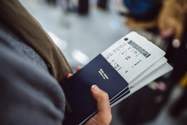 Person holding passport and boarding pass at airport.